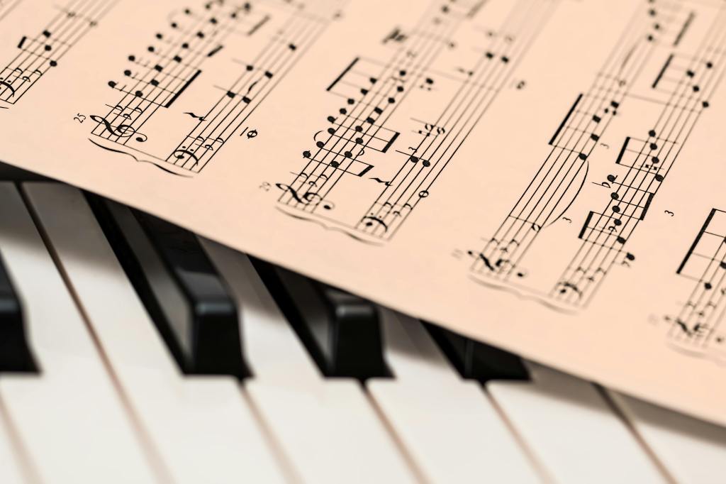 A sheet of classical music placed over a piano keyboard